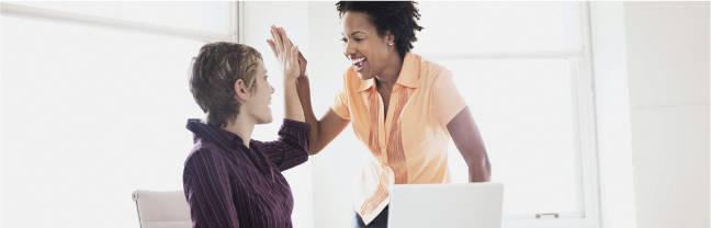 Two women high-fiving each other